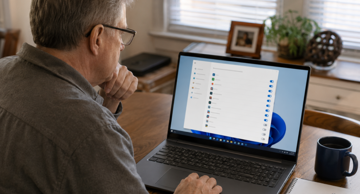 Older computer user reviewing Windows startup apps on an entry-level laptop